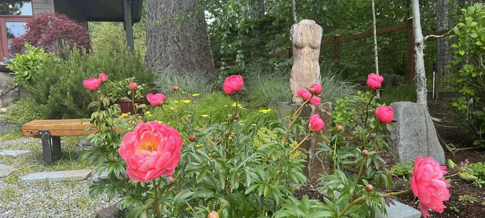 A statue of a woman in the middle of a garden.