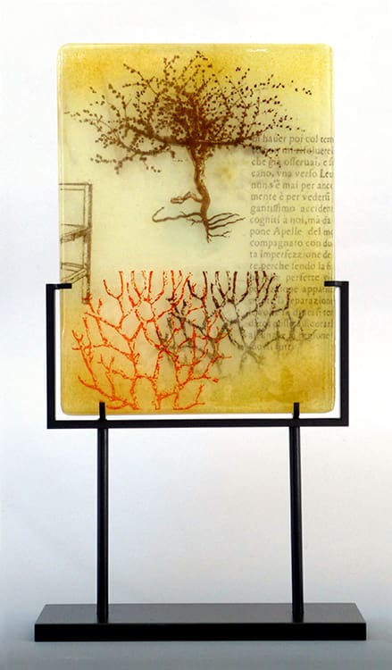 A glass panel with trees and writing on it.
