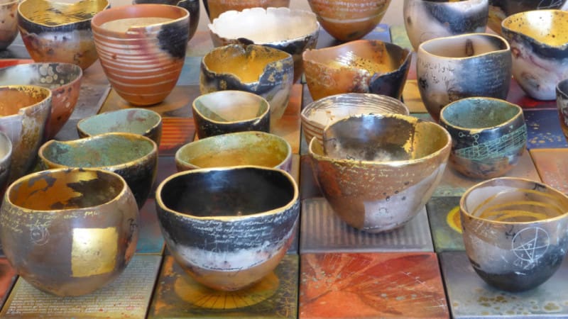 A table with many different bowls and cups.