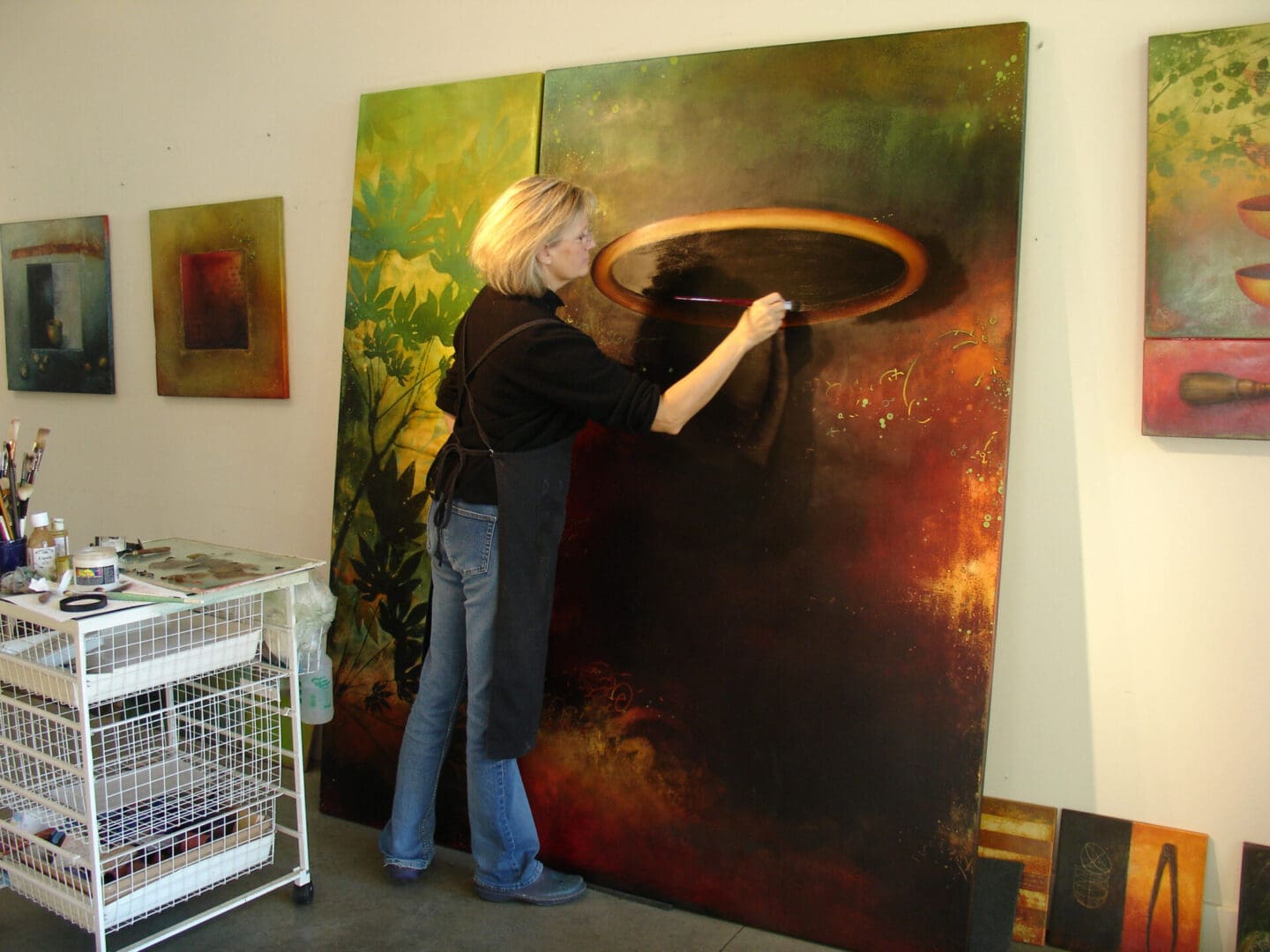 A woman is painting an image on the wall.