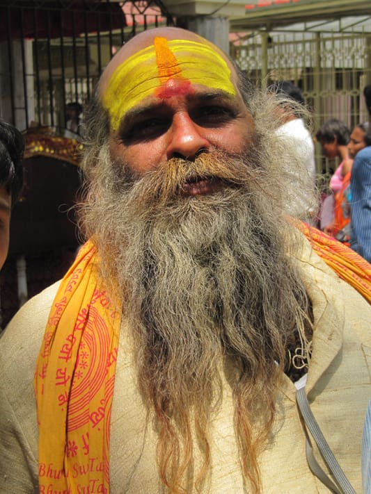 A man with long hair and beard wearing a yellow turban.