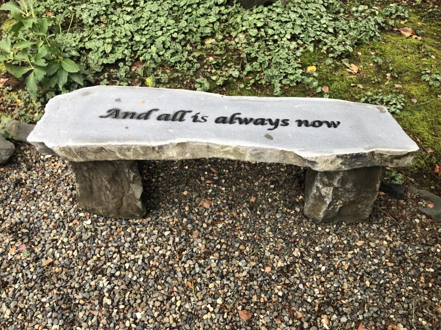 A stone bench with the words " and all is always now ".