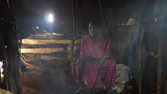 A woman sitting in front of a fire.