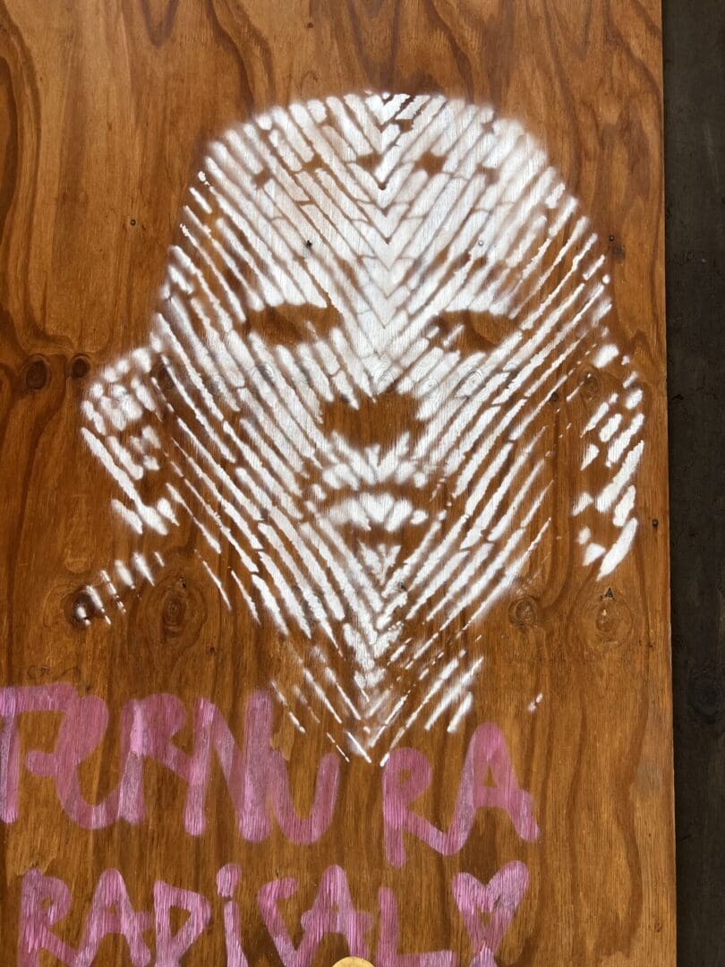 A painting of a face on a piece of wood.